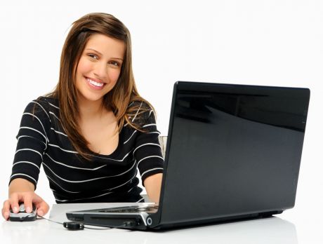 Dziewczyna przy laptopie - uśmiechnięta w sweterku w paski