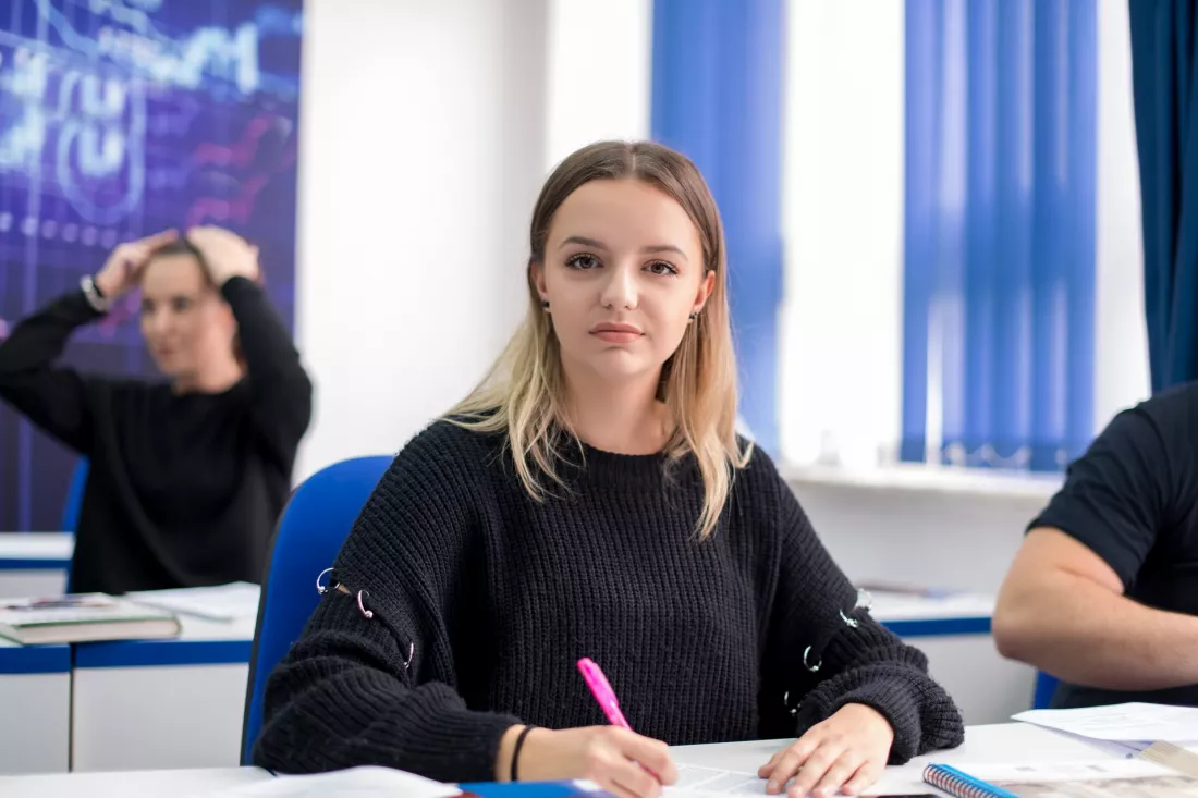 Uczennica robi notatki na lekcji jezyka obcego w szkolnej klasie