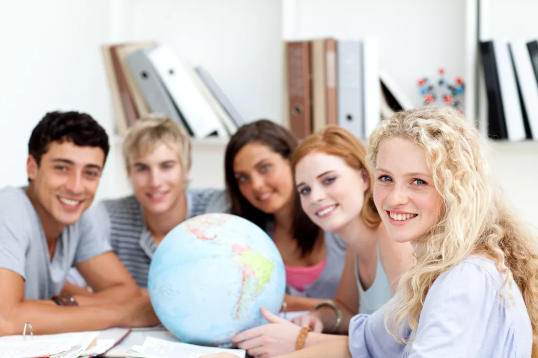 smiling-teenagers-library-working-with-terrestrial-globe